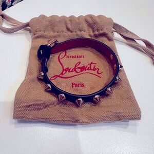 Black leather with metal spikes and Louboutin red interior bracelet.